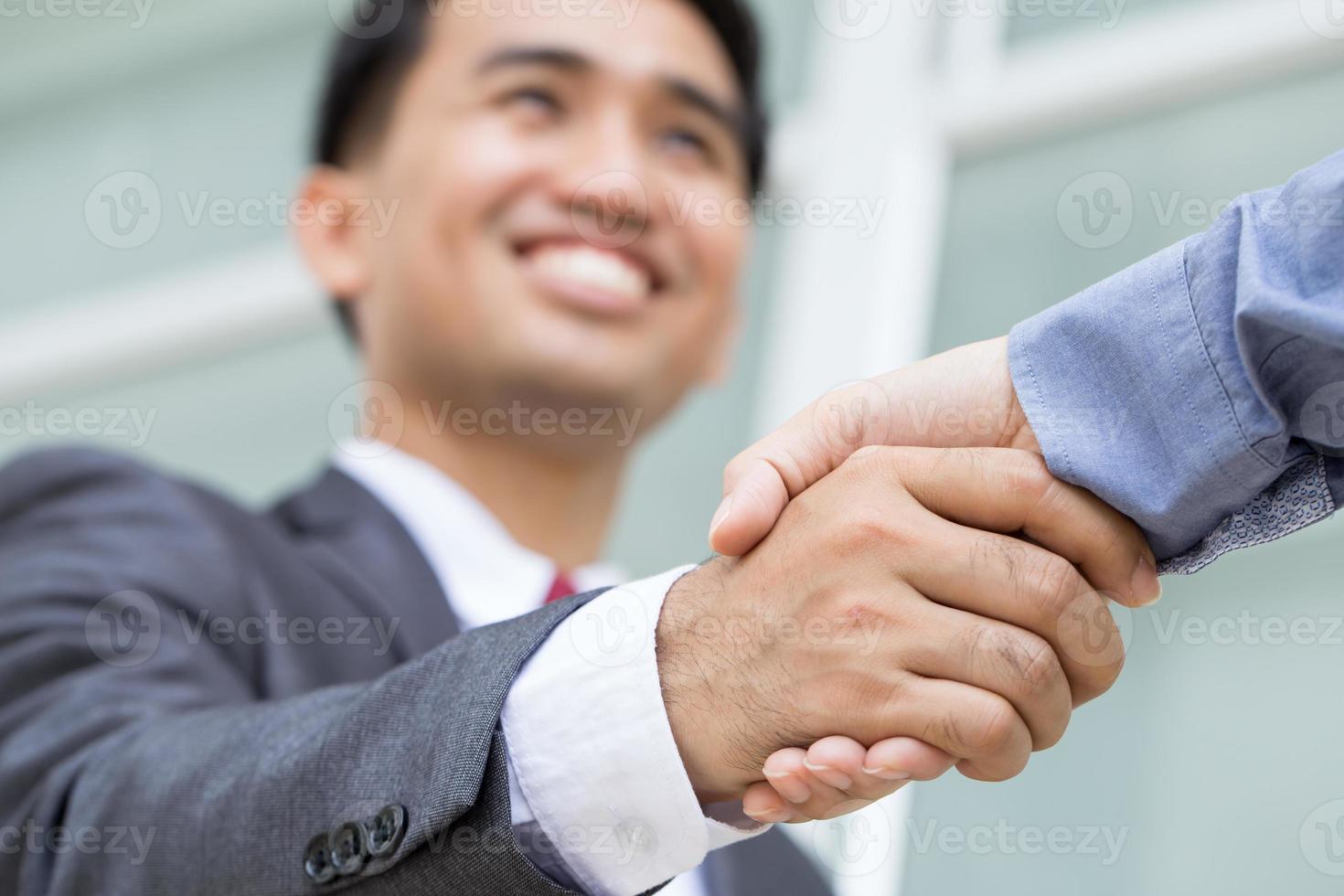 Aziatische zakenman handdruk met lachende gezicht maken foto