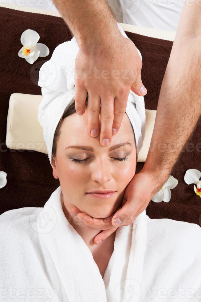 jonge vrouw ontvangen hoofdmassage in spa foto