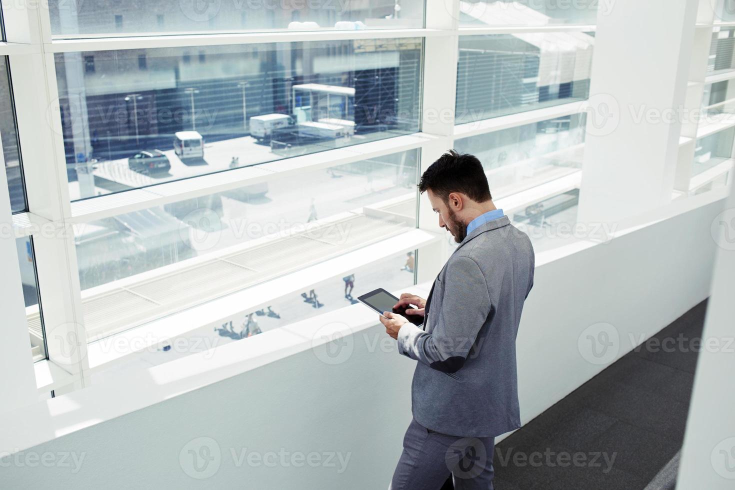 succesvolle mannelijke CEO met behulp van digitale tablet tijdens werkpauze foto