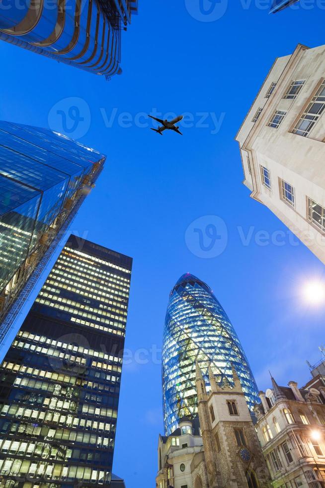 jet vliegtuig silhouet met zakelijke kantoorgebouw torens achtergrond foto