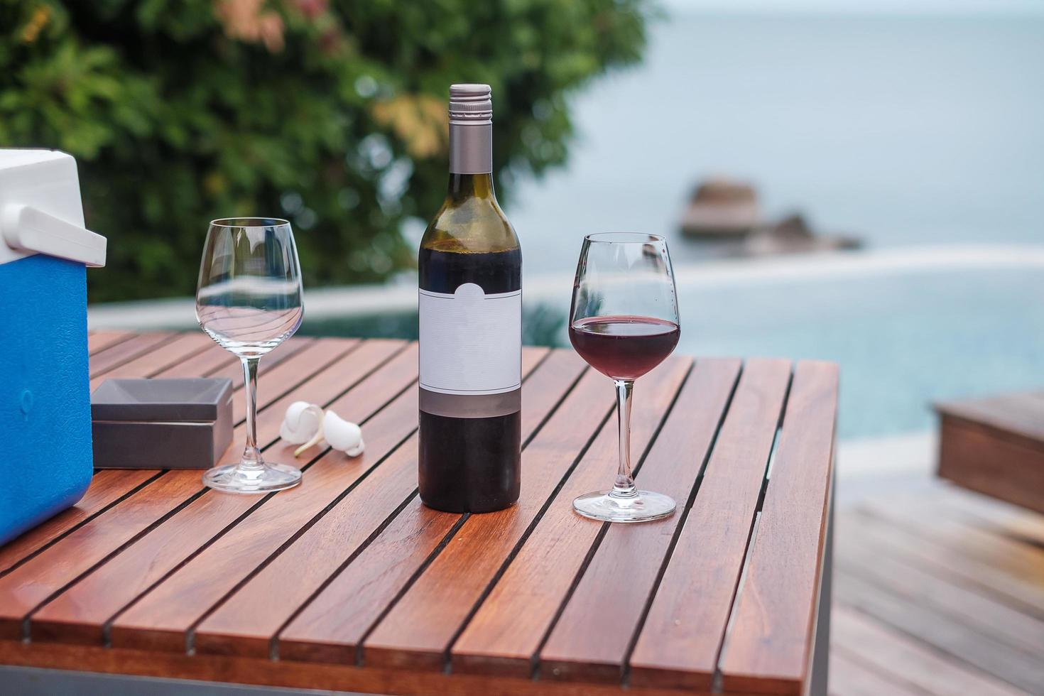 twee rode wijnglazen dichtbij zwembad. zomer reizen, vakantie, vakantie en gelukkig weekend concept foto