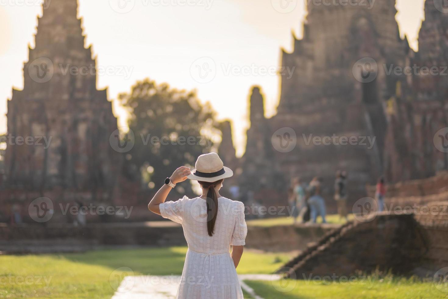 toeristische vrouw in witte jurk met chirurgisch gezichtsmasker, bescherming covid-19 pandemie tijdens een bezoek aan de wat chaiwatthanaram-tempel in ayutthaya. nieuw normaal, veiligheidsreizen en reisconcept Thailand foto
