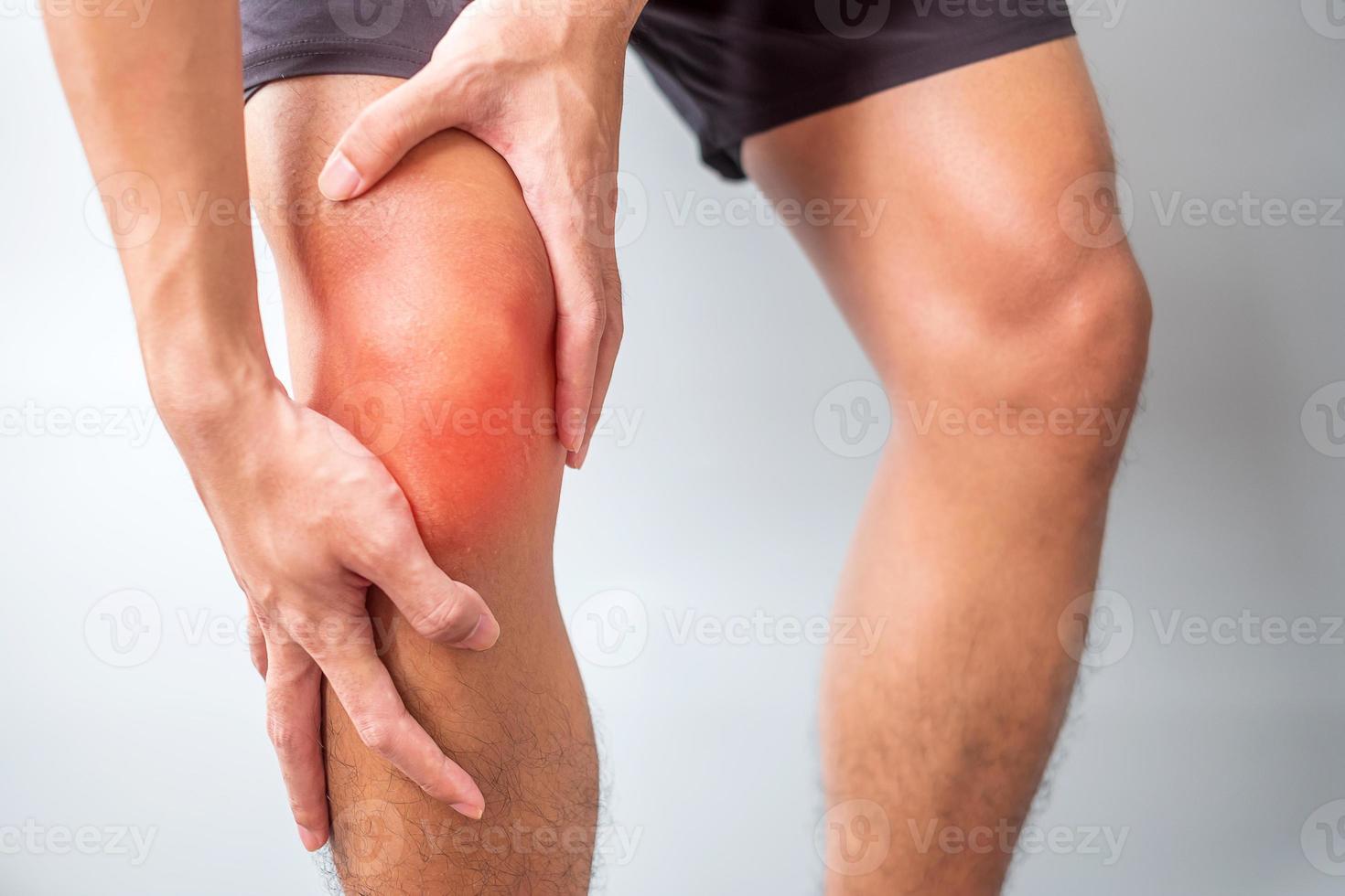 man met spierpijn op grijze achtergrond. ouderen hebben kniepijn als gevolg van runners knee of patellofemoraal pijnsyndroom, artrose, artritis, reuma en patellatendinitis. medisch concept foto