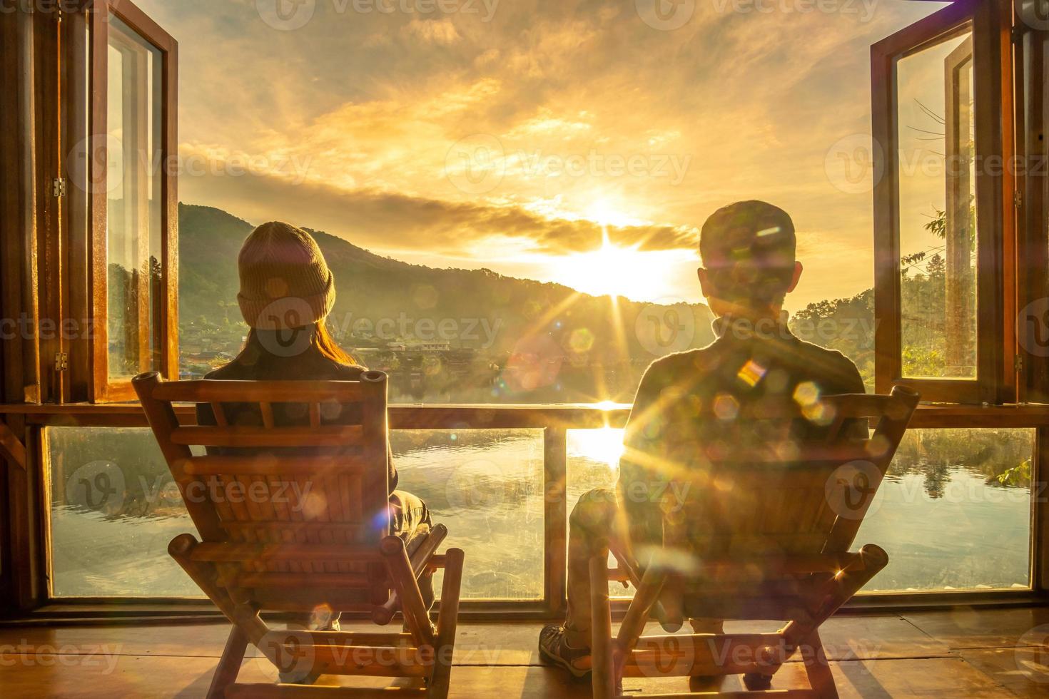 gelukkig jong stel kijken naar uitzicht op het meer bij coffeeshop in de ochtendzonsopgang, verbod rak thai village, mae hong son provincie, thailand. reizen, samen en romantisch concept foto