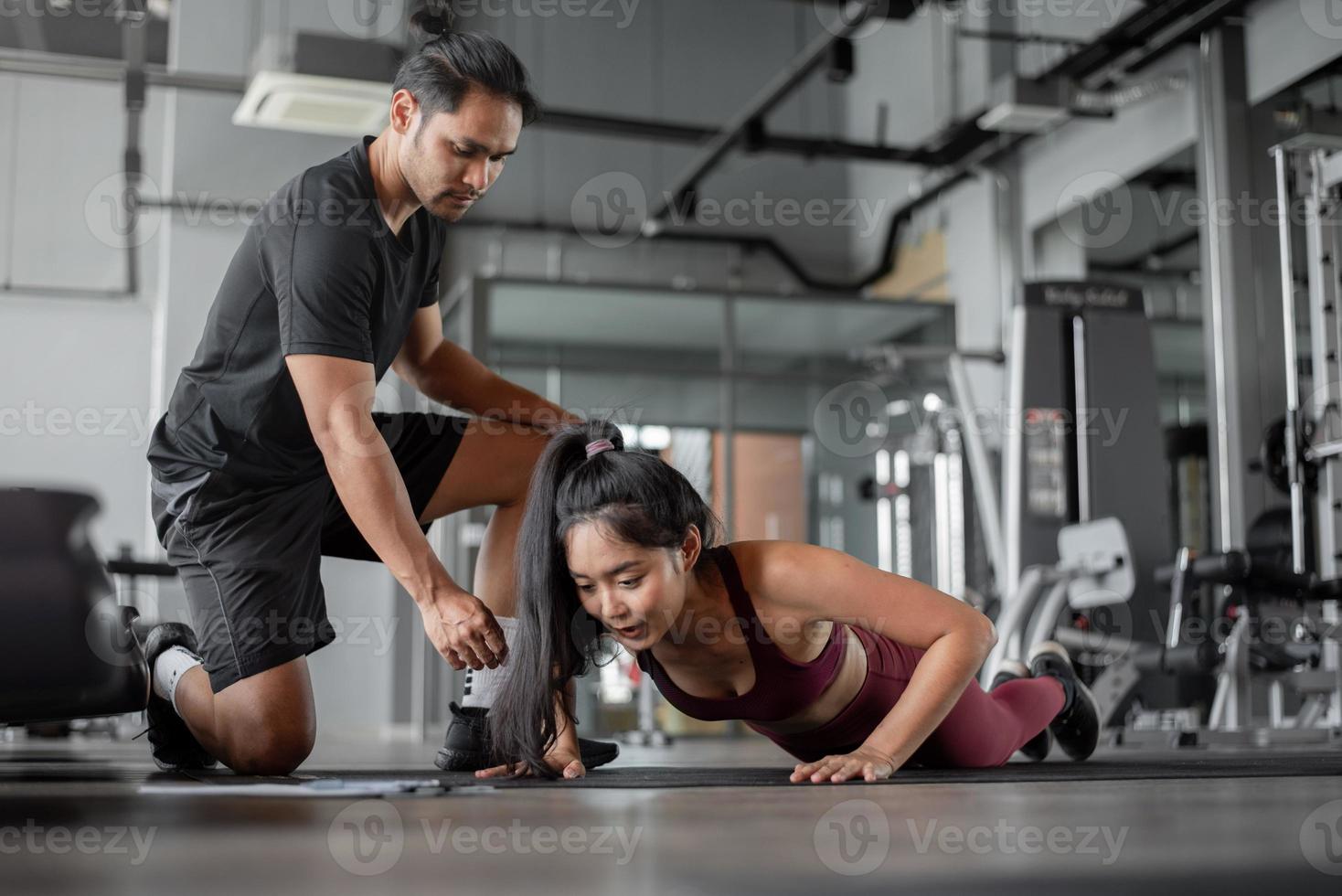 aziatische vrouw oefenen met personal trainer in de sportschool. jonge gezonde vrouw training in fitnees met persoonlijke coach. oefeningen en fitness concept. foto