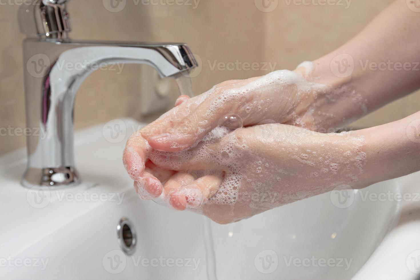 hygiëne. handen schoonmaken. handen wassen met zeep. vrouwenhand met schuim. bescherm jezelf tegen coronavirus covid-19 pandemie foto