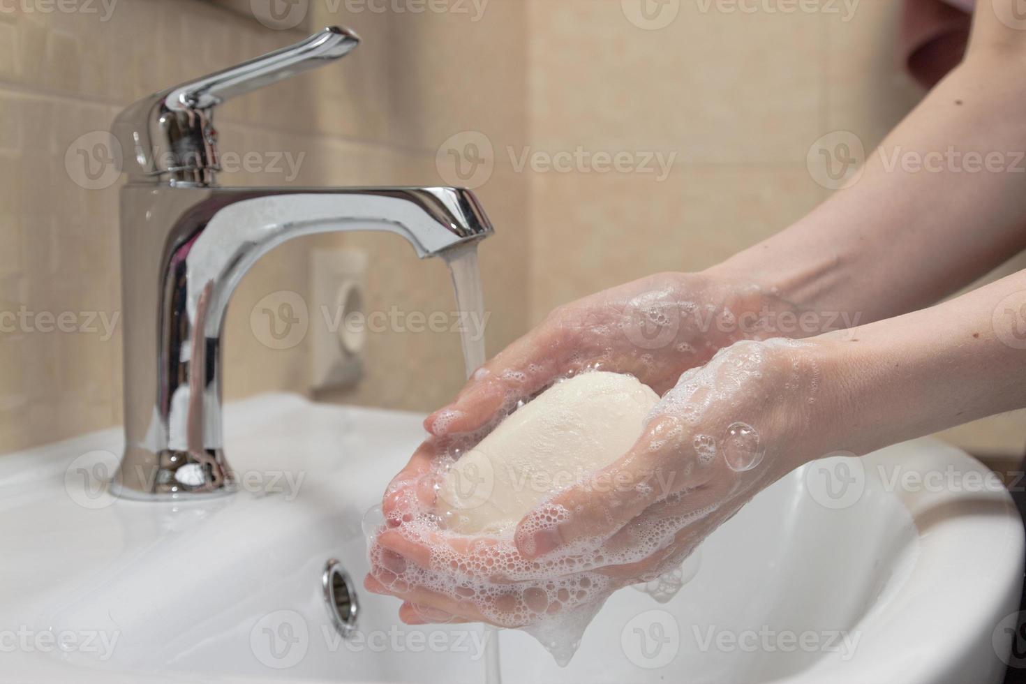 hygiëne. handen schoonmaken. handen wassen met zeep. vrouwenhand met schuim. bescherm jezelf tegen coronavirus covid-19 pandemie foto