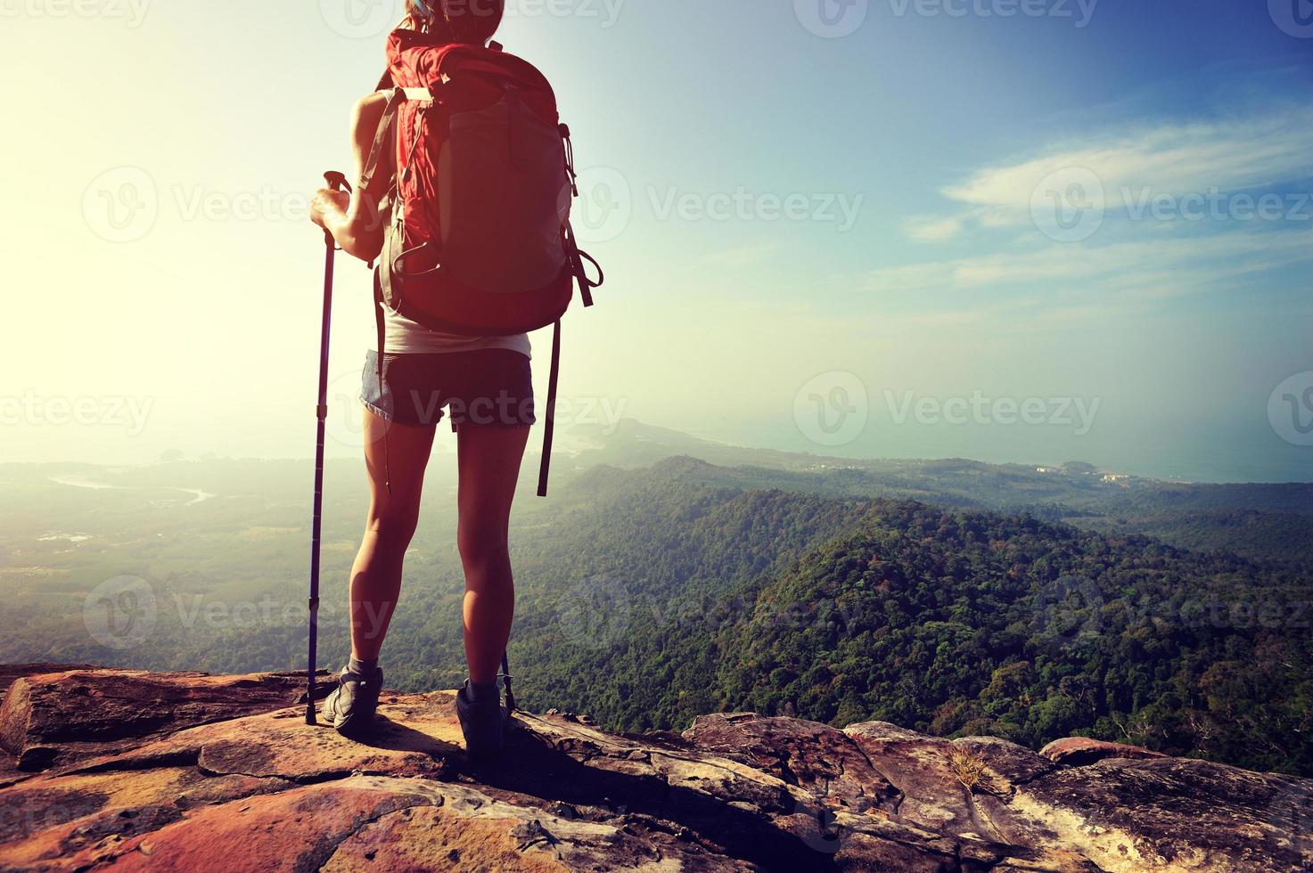 vrouw wandelaar geniet van het uitzicht op de bergtop klif foto