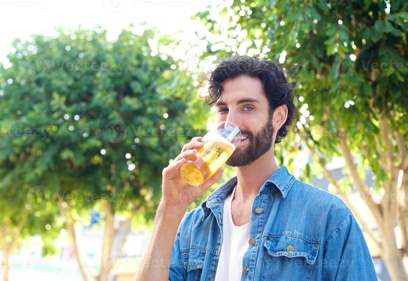 man genieten van een drankje van bier in de buitenbar foto