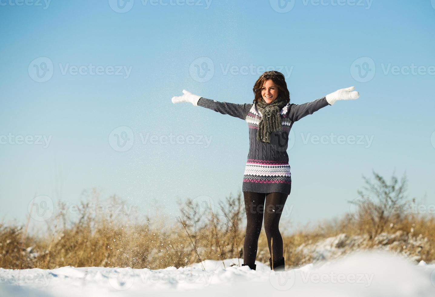 portret van een jonge vrouw plezier hebben en genieten van verse sneeuw foto