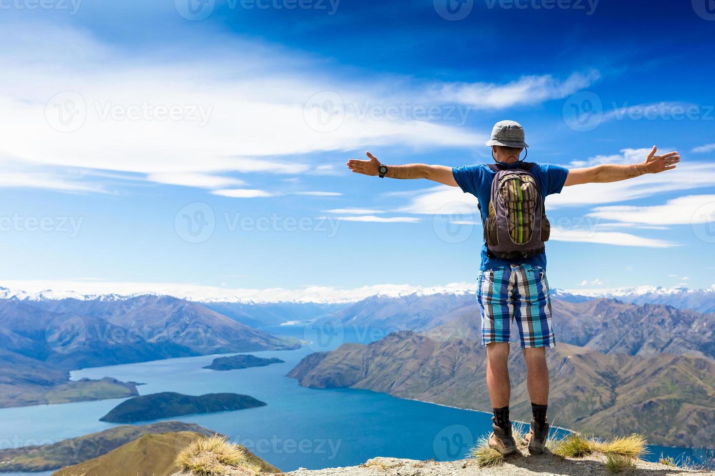 wandelaar op de top van een rots genieten van zonnige dag foto