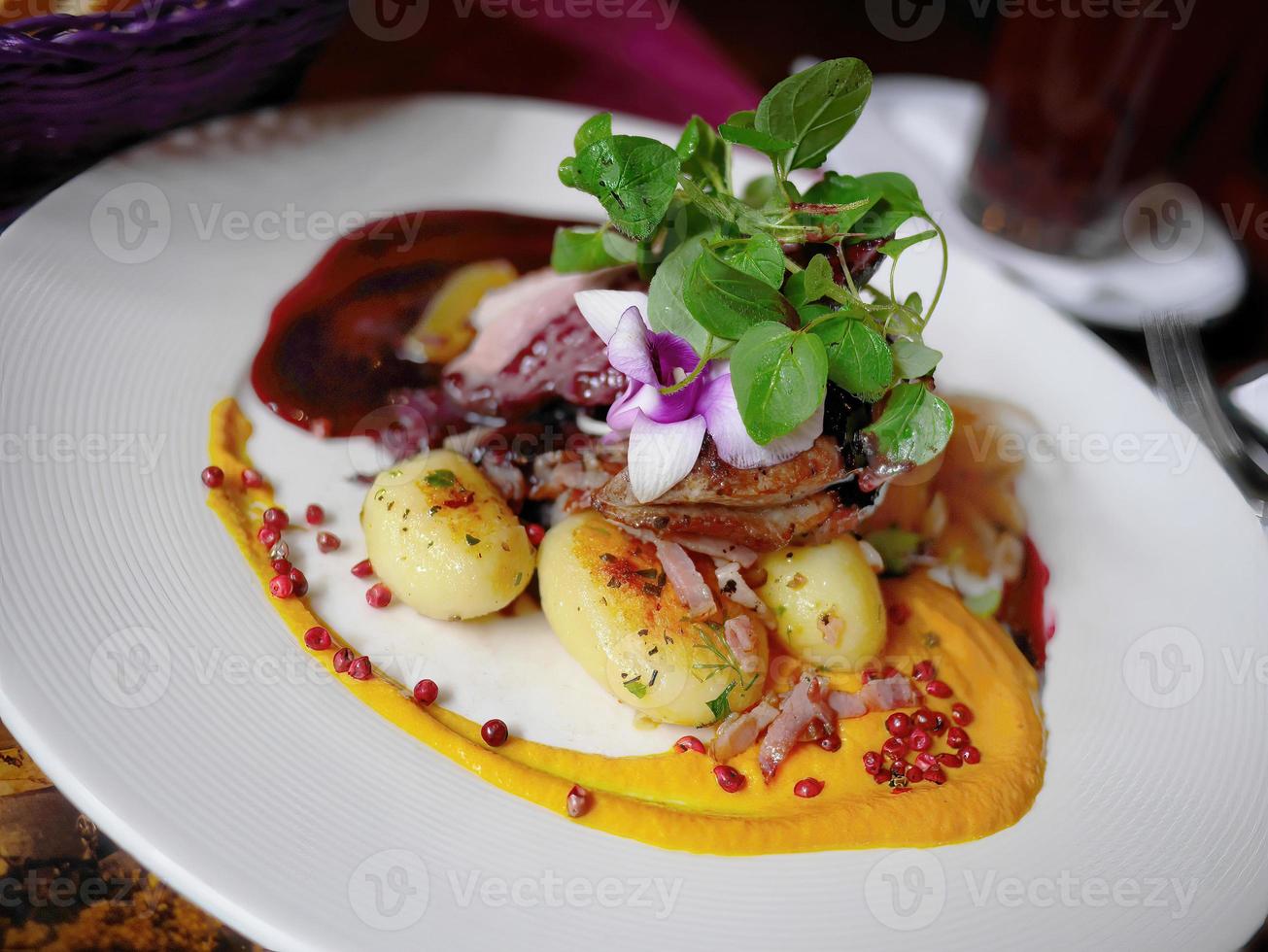 close-up mooie voedseldecoratie met orchidee, roze peper, groen blad, levendig kleurrijk gerecht, voedselbehang foto