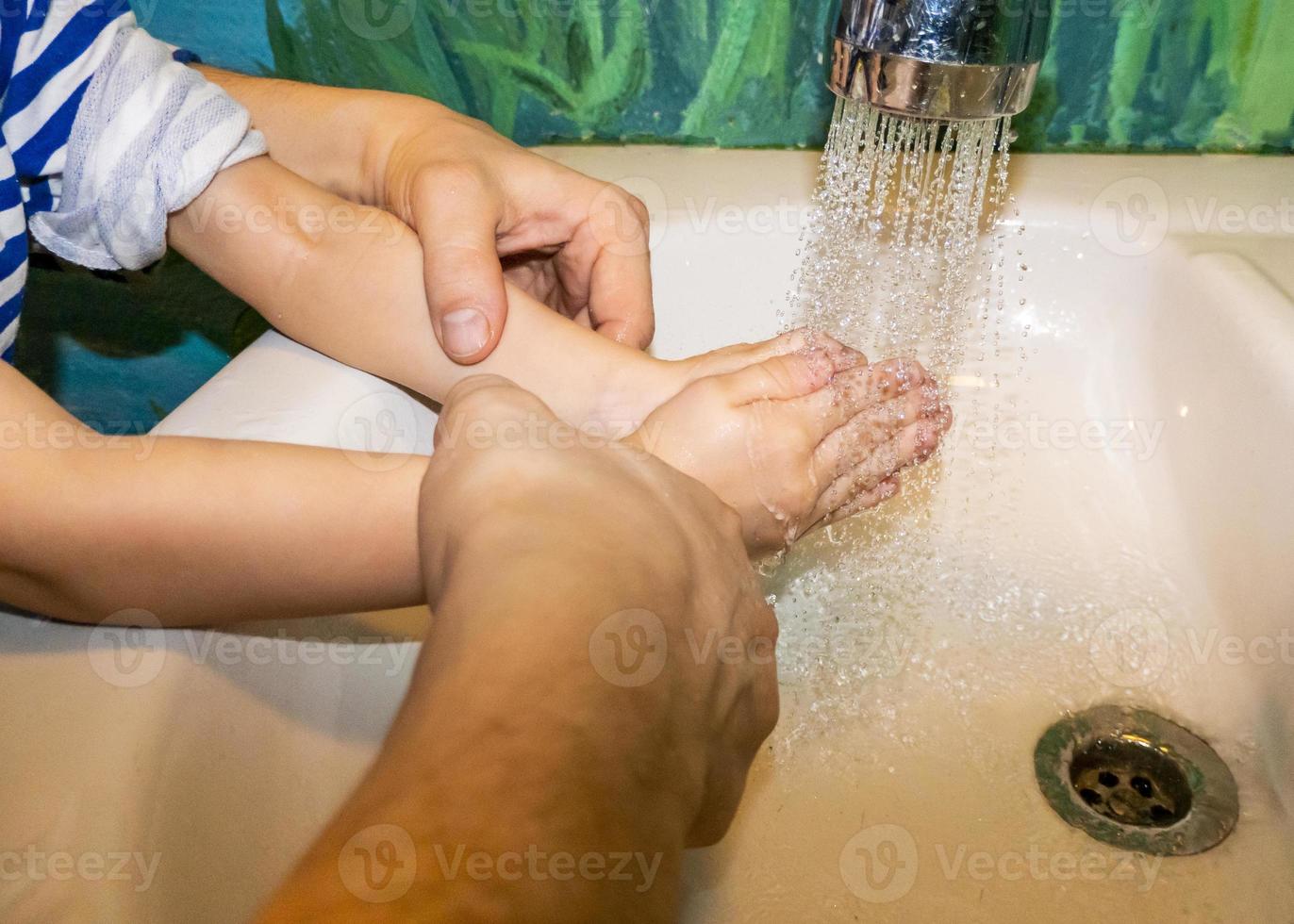 close-up van blanke man en kind wast zijn handen in de badkamer. covid - 19 preventie foto