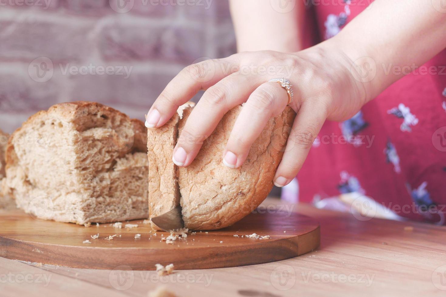 vrouwen snijden gebakken voorhoofd brood op tafel. foto
