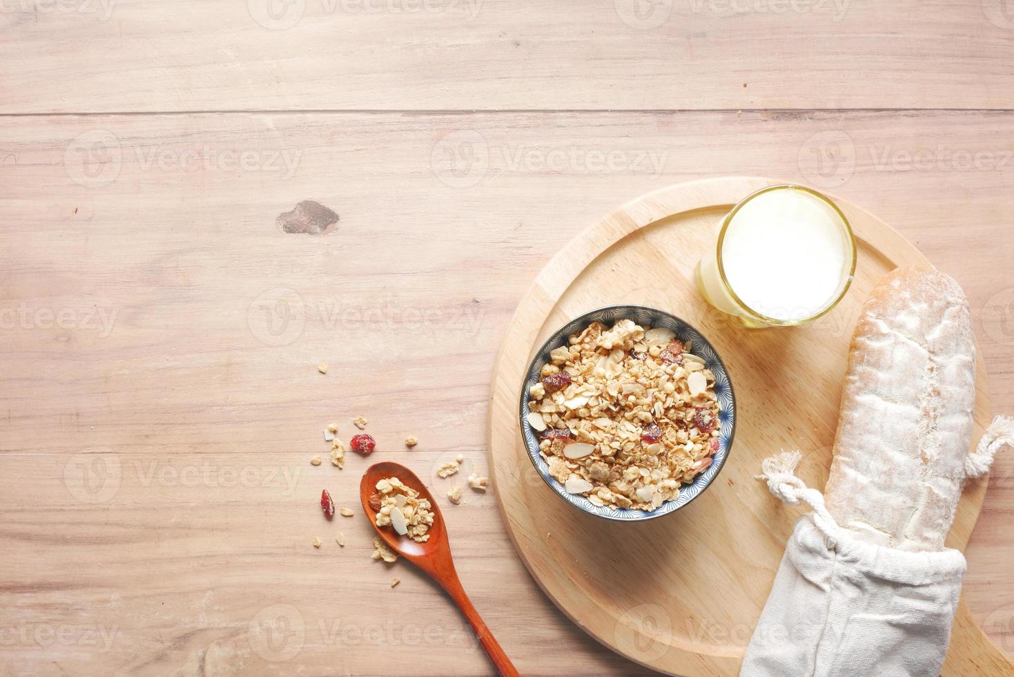 zelfgemaakte musli in een kom, brood en melk op tafel foto