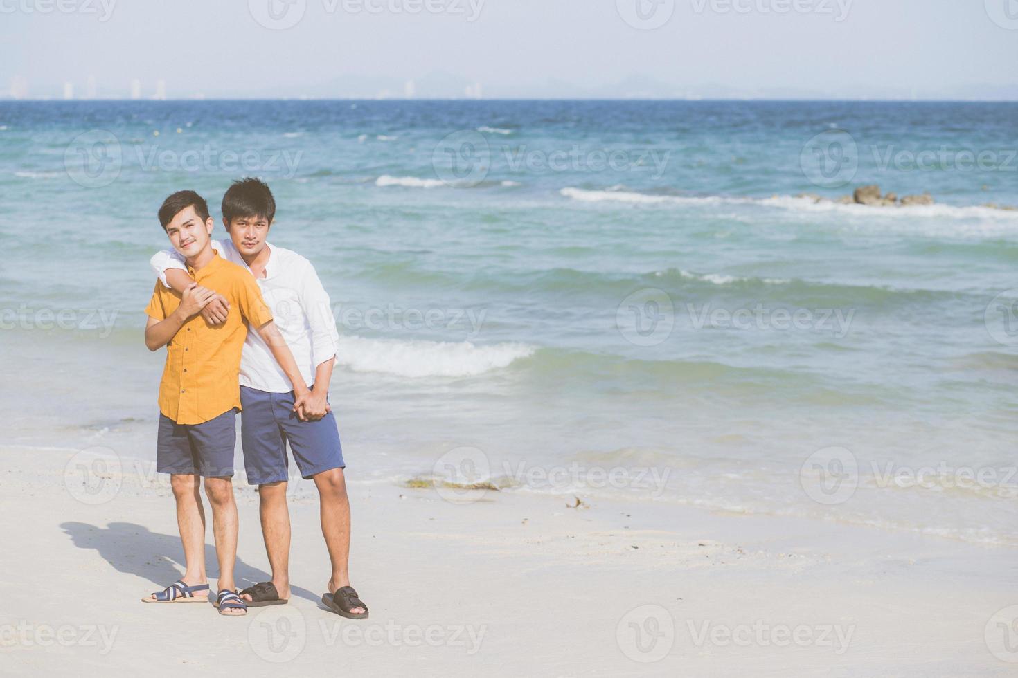 homoseksueel portret jong aziatisch paar staande knuffel samen op het strand in de zomer, azië homo gaand toerisme voor vrije tijd en ontspannen met romantisch en geluk in vakantie op zee, lgbt-concept. foto