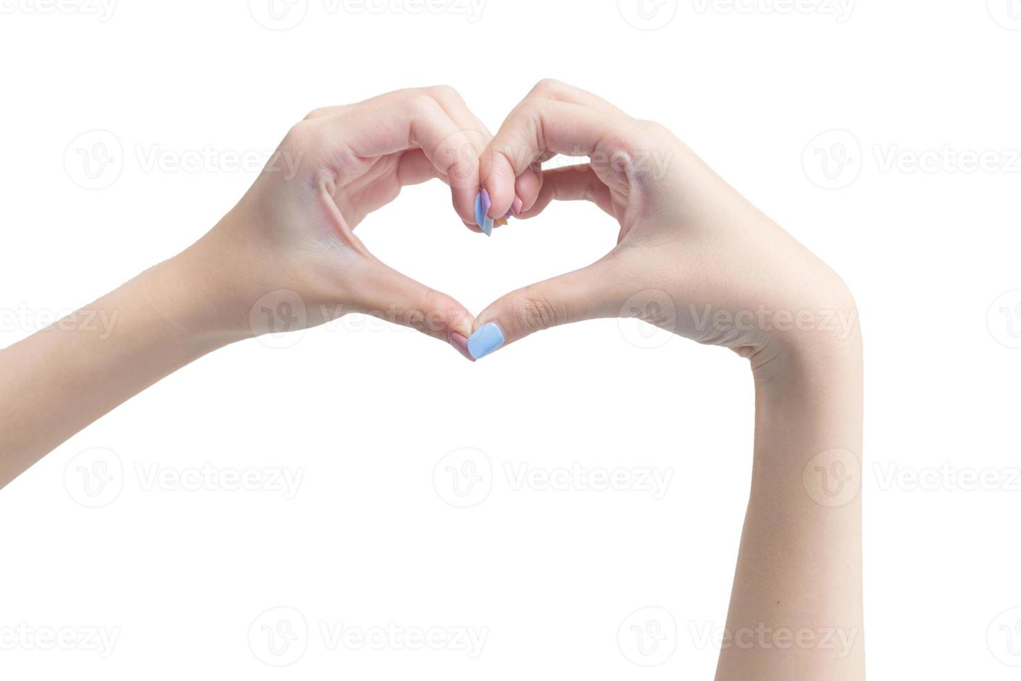mooie vrouwelijke hand toont hartsymbool als liefdesteken op een witte achtergrond in manicureconcept. foto