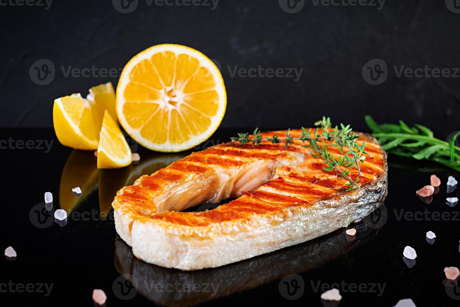 gegrilde zalm vis op stenen bord. Salt atlantic zalm gebakken op grill met citroen foto