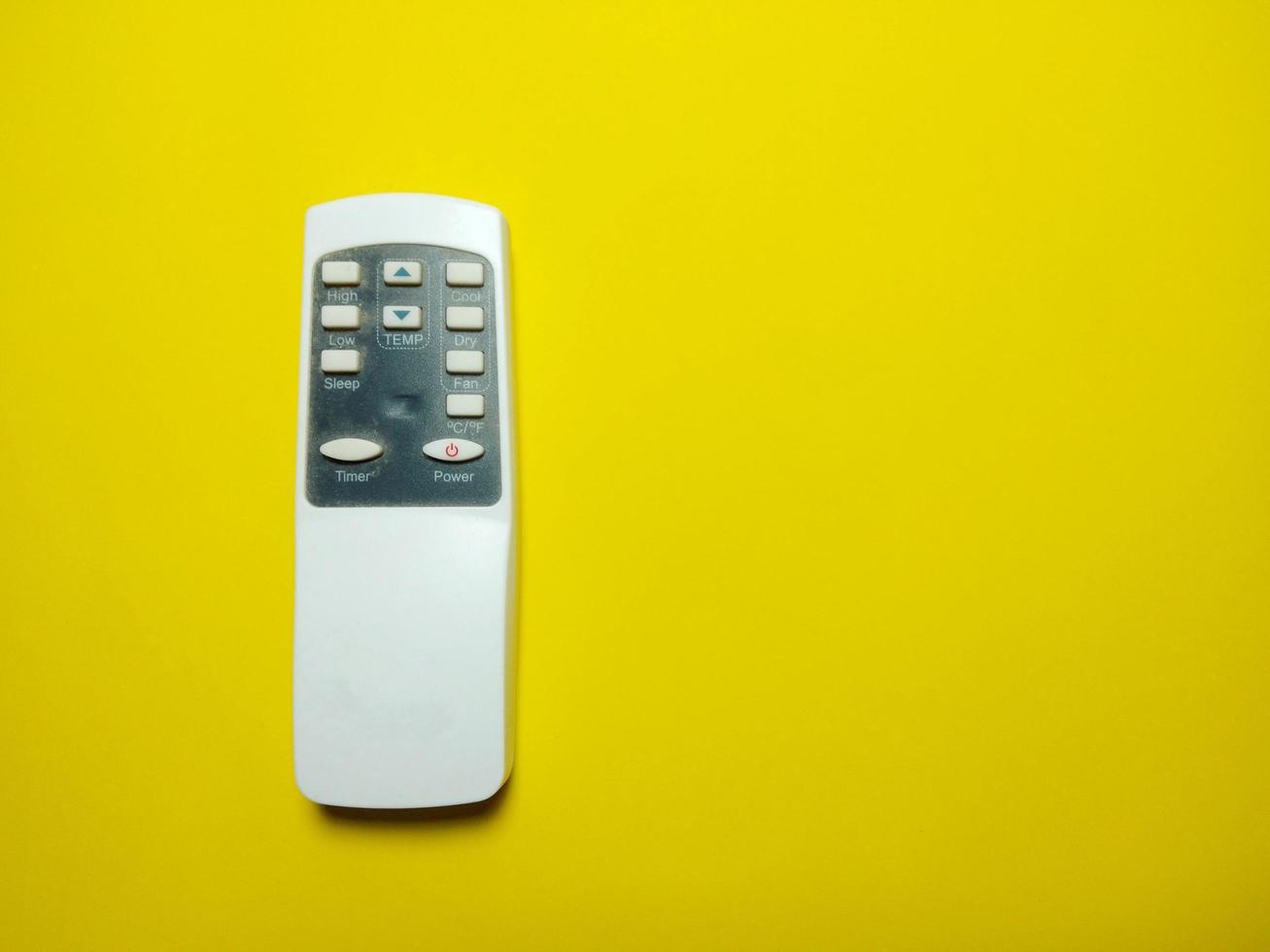 witte afstandsbediening geplaatst op een gele achtergrond afstandsbediening concept technologische vooruitgang voelt geweldig foto