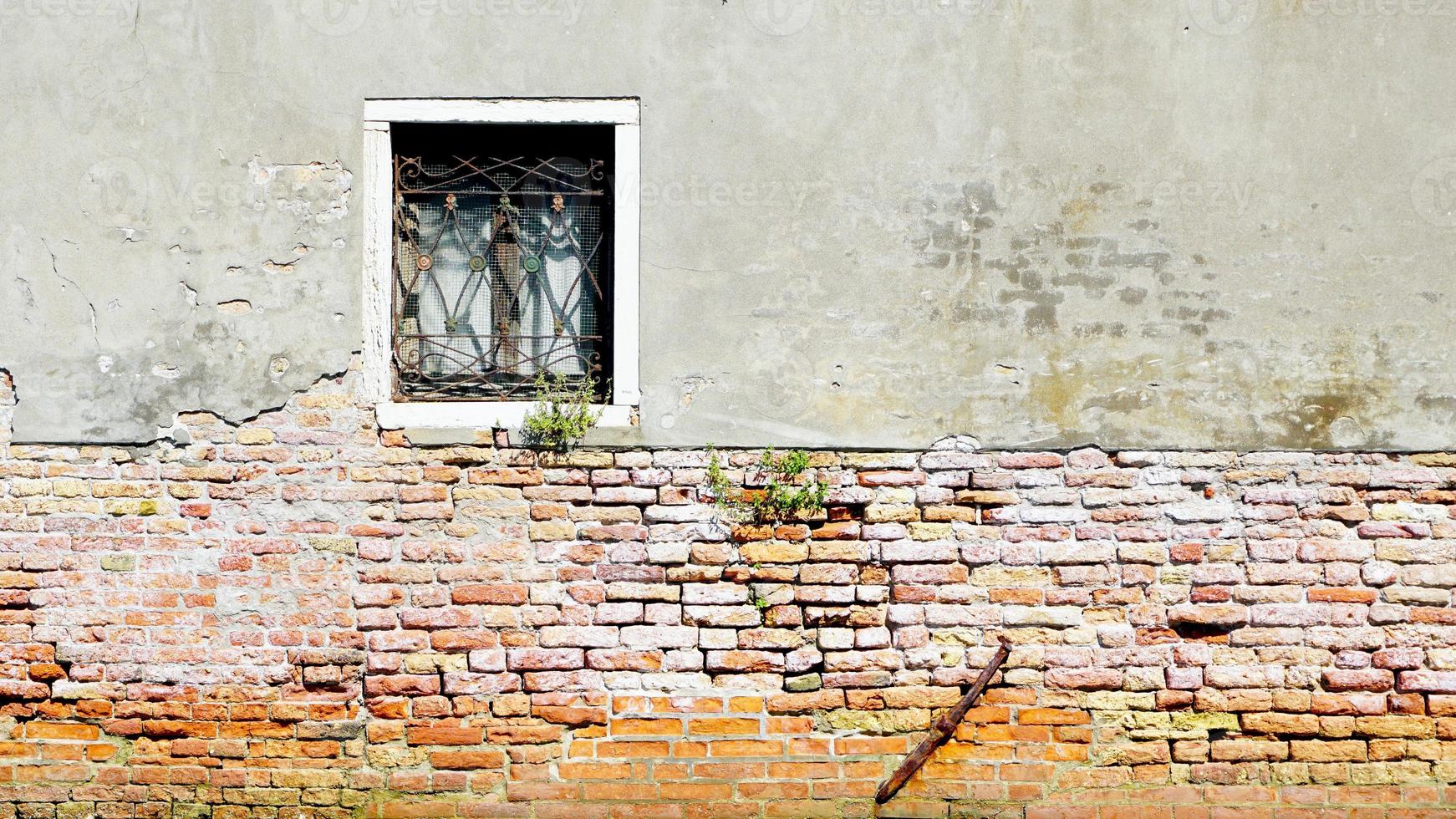 raam en oude vervalmuur halve bakstenen muur in venetië, italië foto