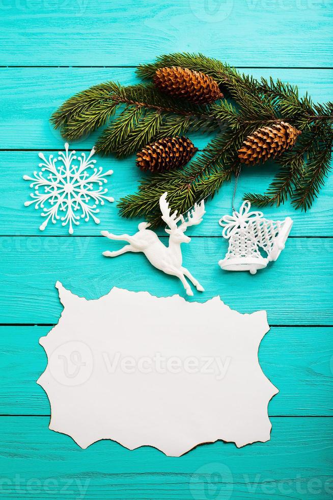 frame van dennenappels op een kerstboom op blauwe houten achtergrond. bovenaanzicht foto