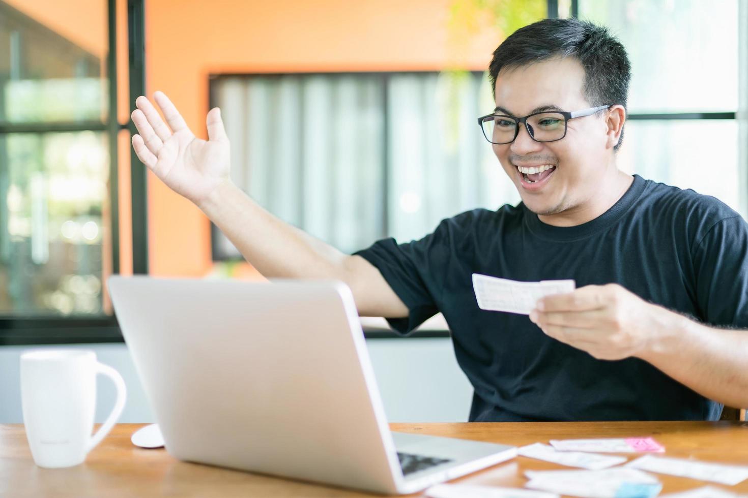 winnend overheidsloterijconcept, Thaise mensen die het resultaat van de Thaise regeringsloterij op laptop controleren en zeer gelukkige actie na het winnen foto