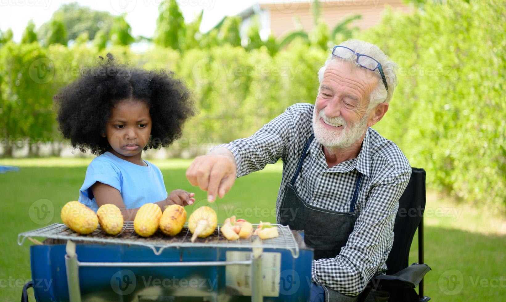 familie vakantie activiteiten met opa en kleinkinderen met camping. bbq grill en speel samen in de tuin gelukkig op vakantie. foto