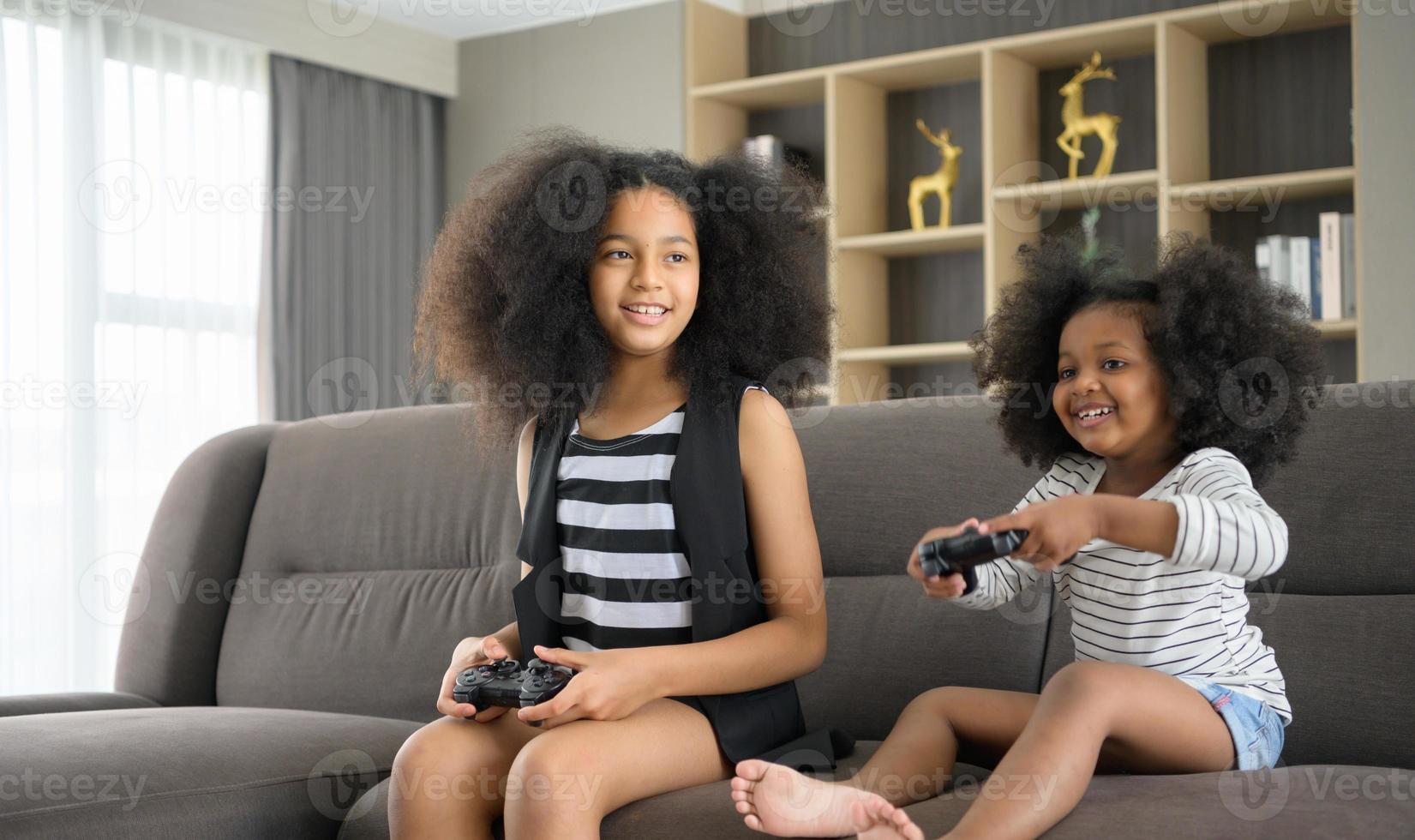 twee broers van een Aziatisch-Afrikaans-Amerikaanse familie. ontspan en speel online games in de woonkamer van het huis. foto