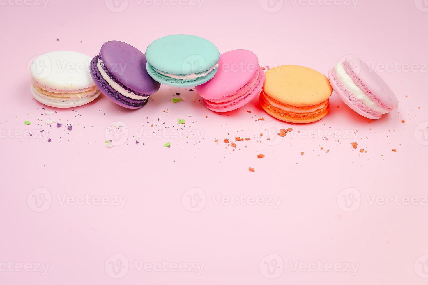 kleurrijke franse macarons bitterkoekjes cake, heerlijk zoet dessert op een roze achtergrond met copyspace, voedsel achtergrond concept. foto