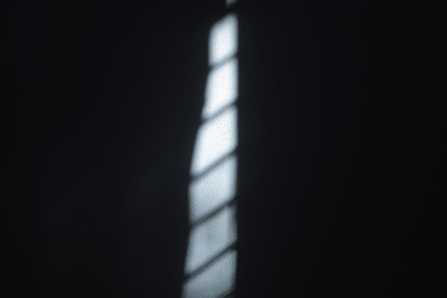 ochtendzonlicht dat door de ramen en glas op een zwarte en blauwe achtergrond schijnt, creëert een effect op de muren van de kamer. foto