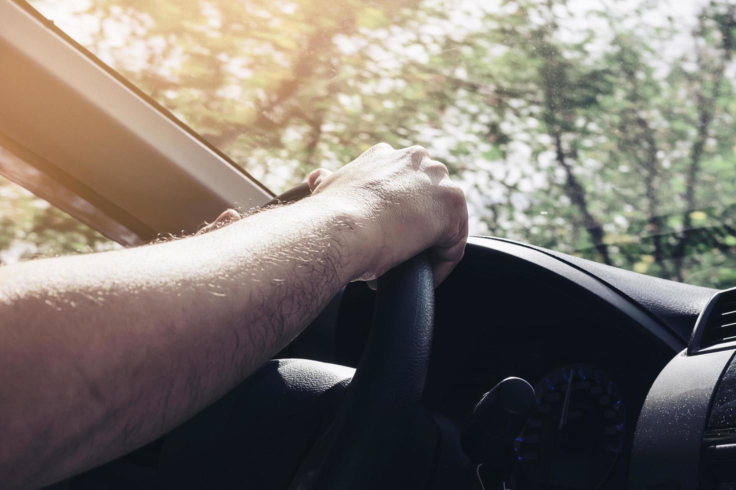 man rijdende auto met één hand foto