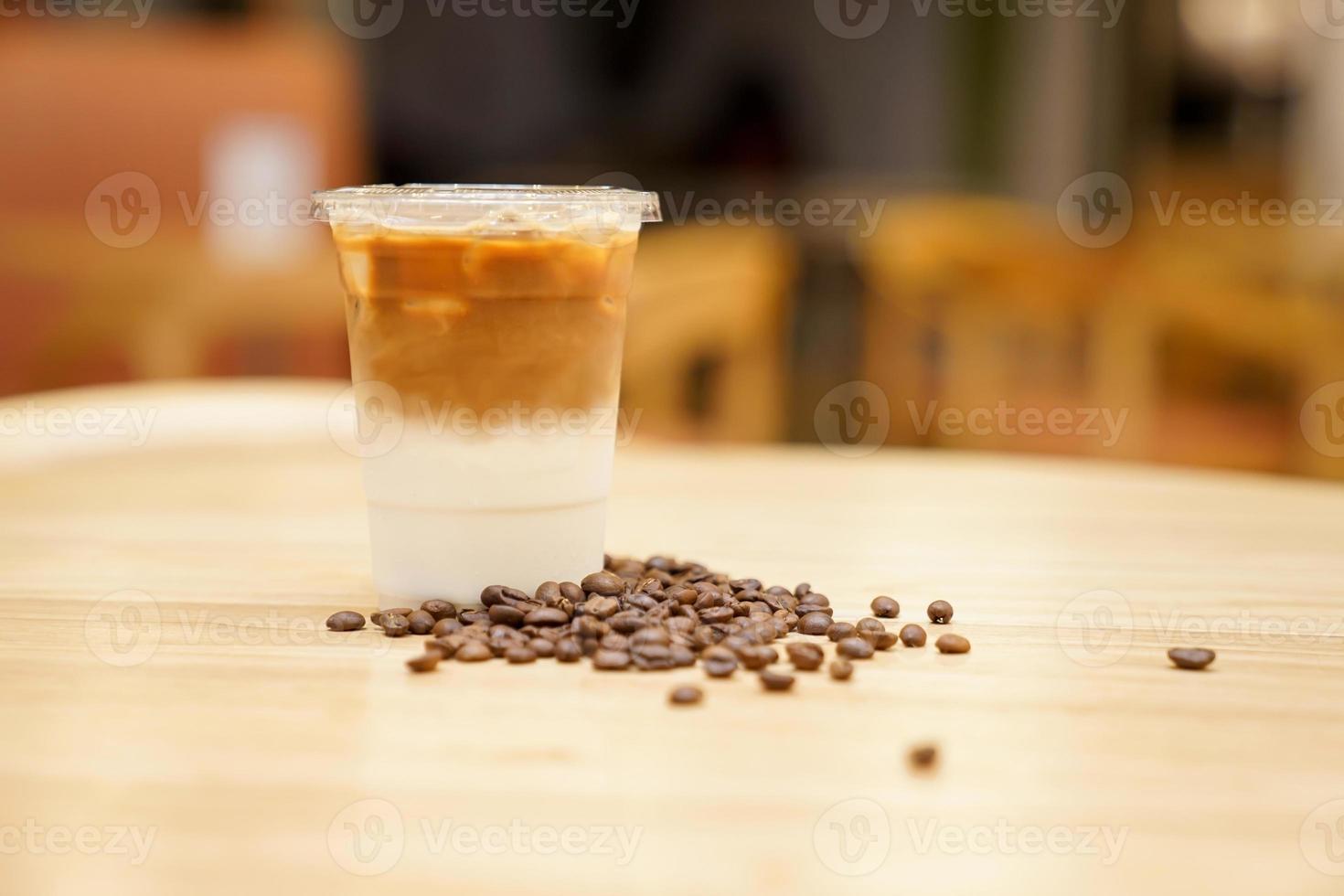 take away latte met koffieboon rond op de houten tafel foto