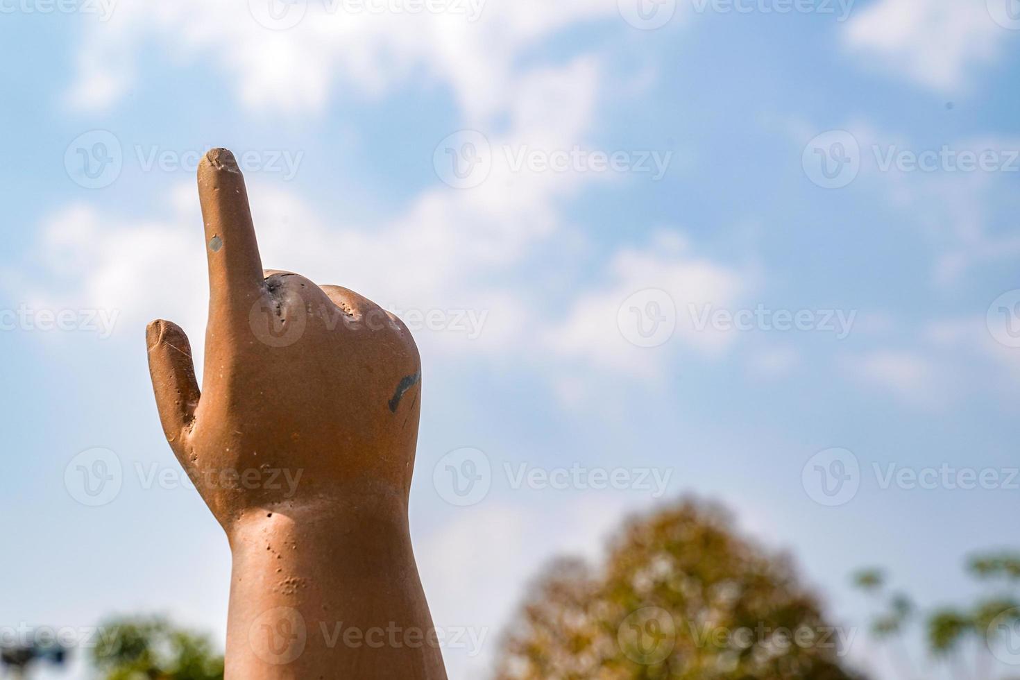 kleine boeddha bronzen koperen beeldje wijst met de vinger naar de lucht. foto