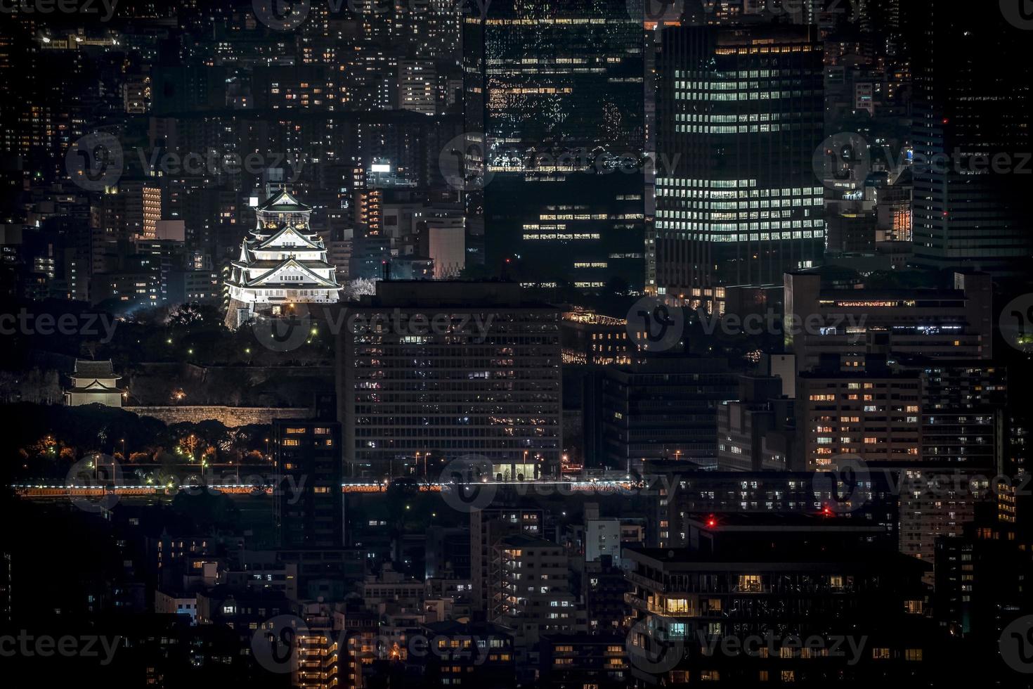 osaka kasteel 's nachts verlicht in birdeye of bovenaanzicht met stadsgezicht en hoog gebouw rond, osaka prefectuur, japan. foto