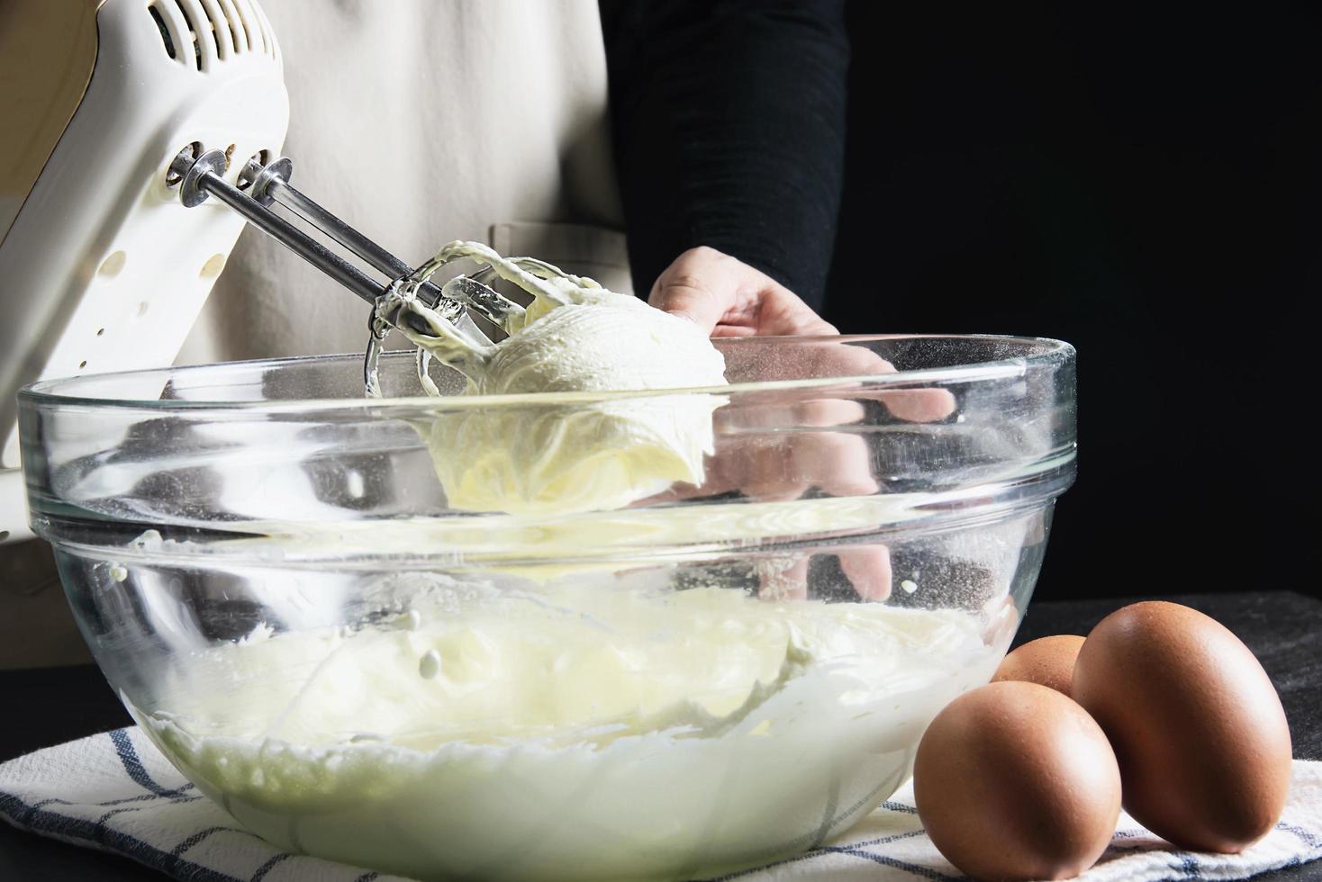 dame die cake maakt die room zet met behulp van spatel - zelfgemaakte bakkerij kookconcept foto