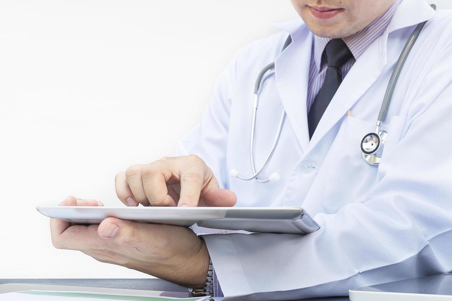 arts werkt met tablet op witte achtergrond foto