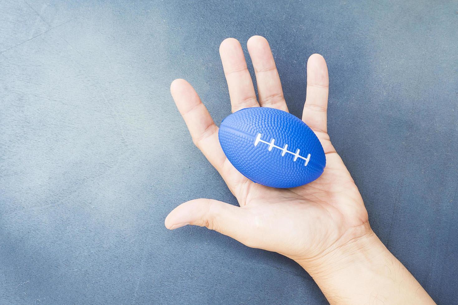 zachte rugbybal in de hand voor hand- en vingertrainer foto