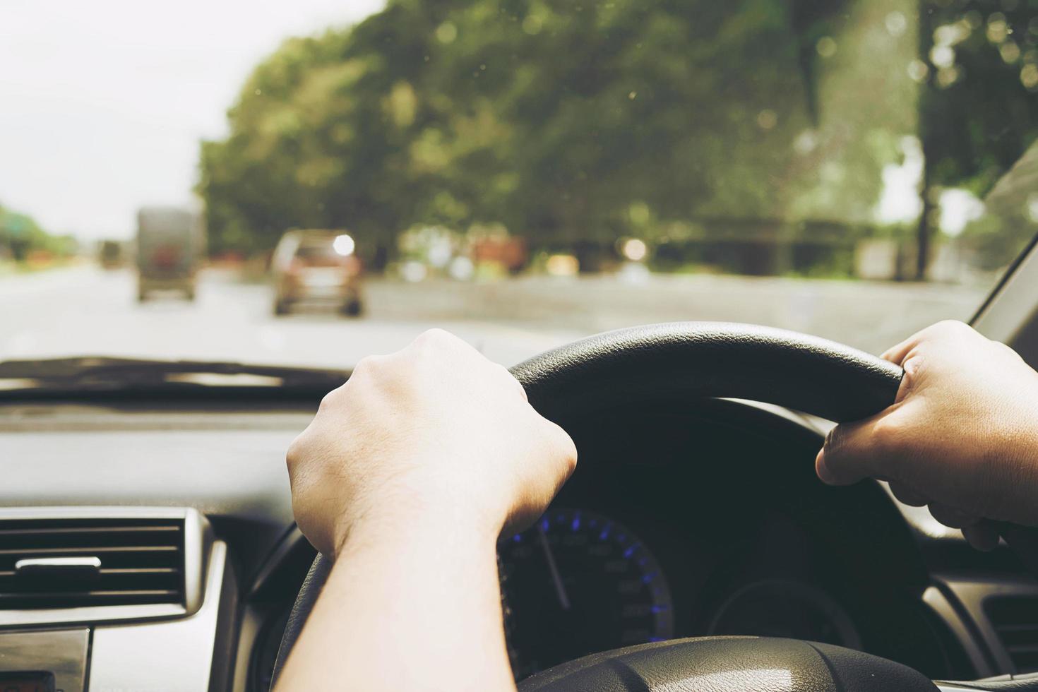 close-up van een man die een auto bestuurt met twee handen foto