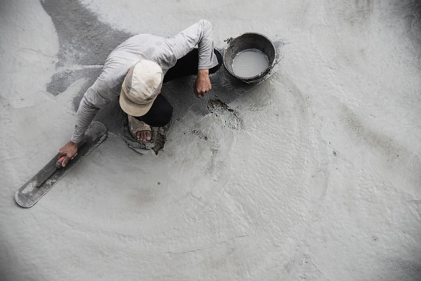 werkman doet wegdek beton gietwerk op bouwplaats foto