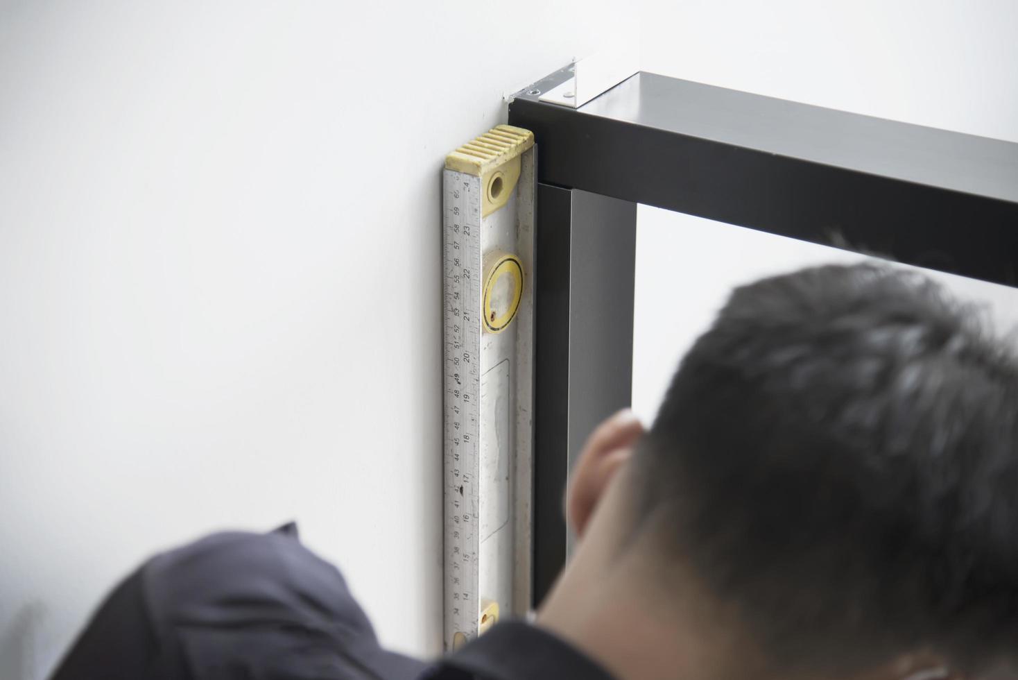 man doet aluminium frame met bril en draadscherm deur en raam installatiewerk op bouwplaats foto