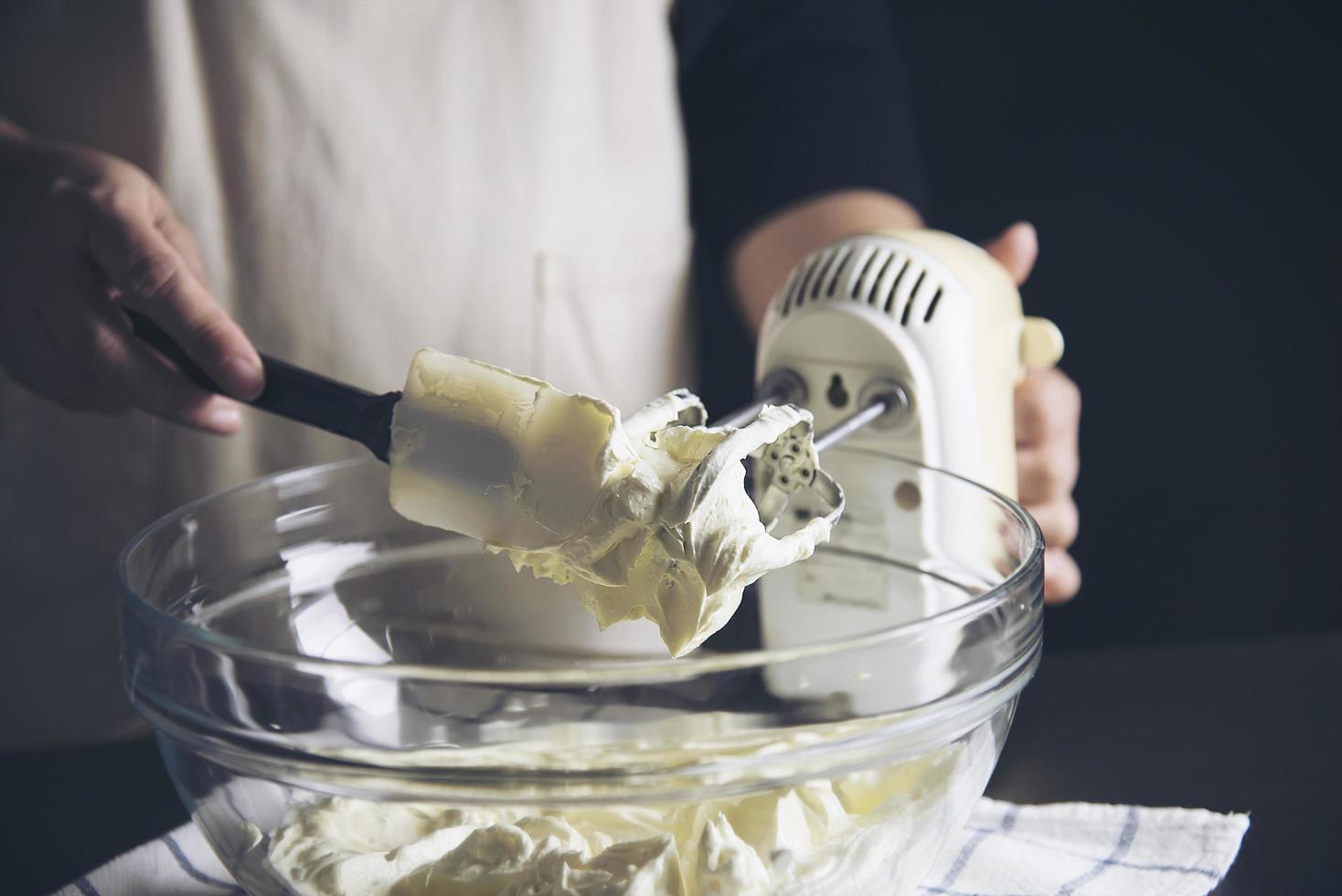 dame die cake maakt die room zet met behulp van spatel - zelfgemaakte bakkerij kookconcept foto