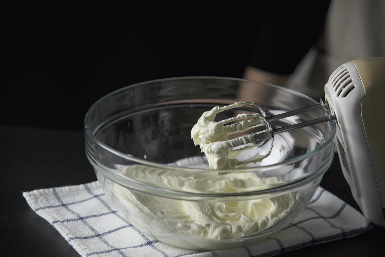 dame die cake maakt die room zet met behulp van spatel - zelfgemaakte bakkerij kookconcept foto