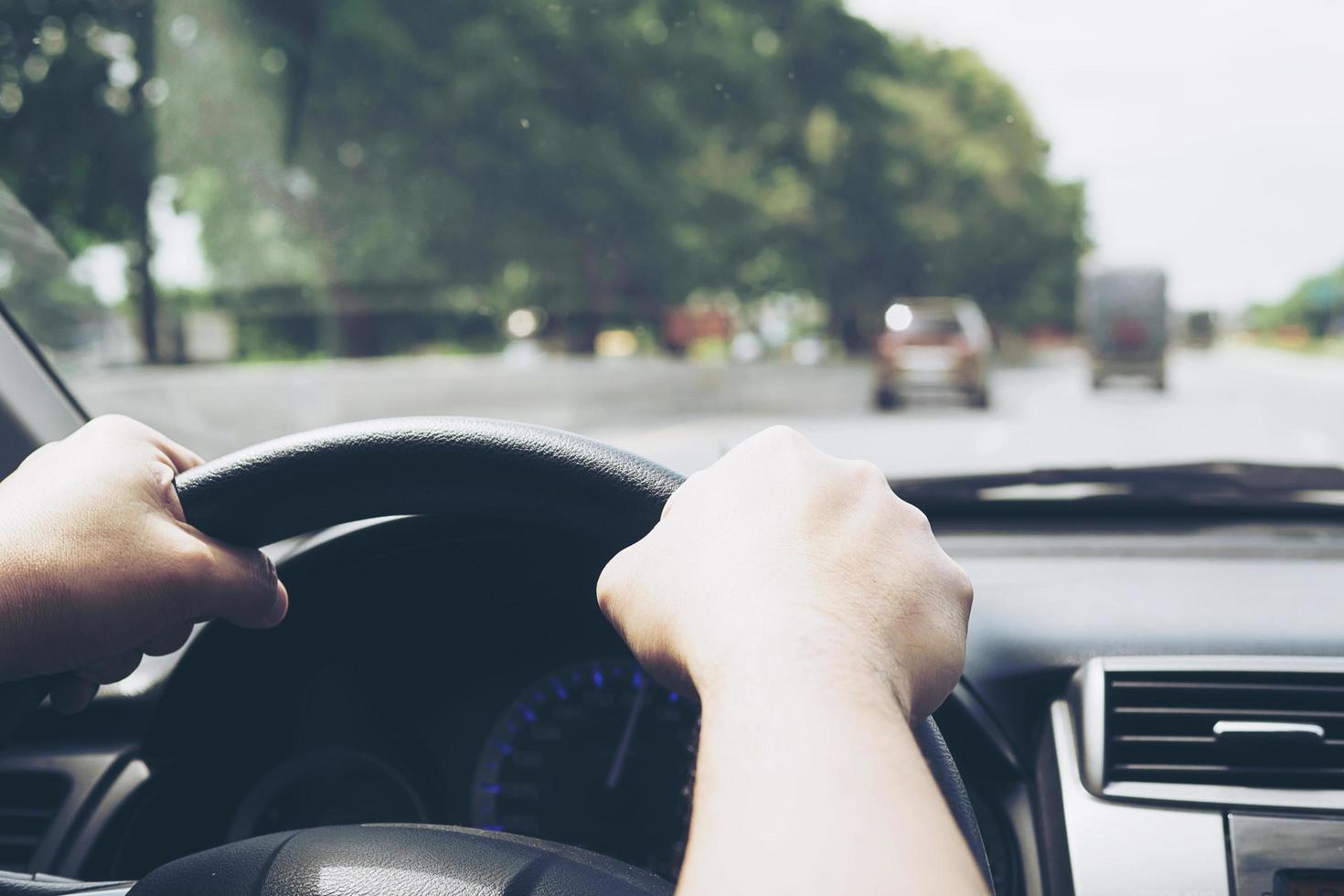 close-up van een man die een auto bestuurt met twee handen foto