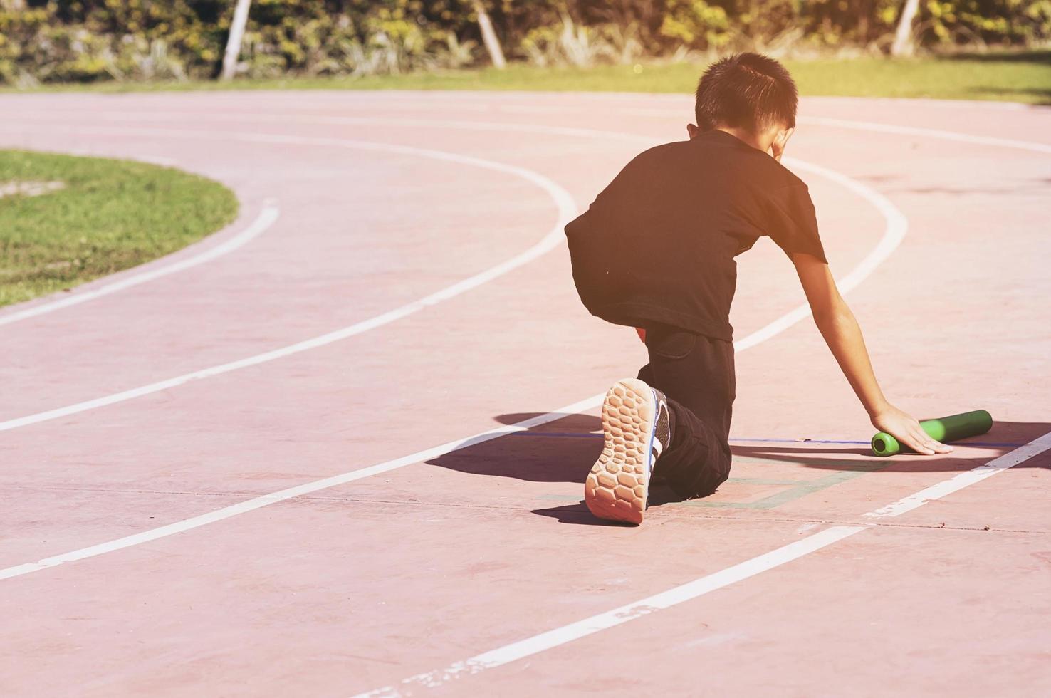 jongen is klaar om te rennen op het startpunt van zijn schoolsportdag foto