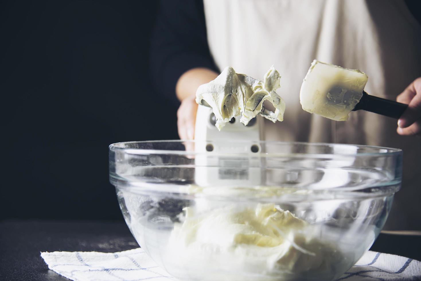 dame die cake maakt die room zet met behulp van spatel - zelfgemaakte bakkerij kookconcept foto