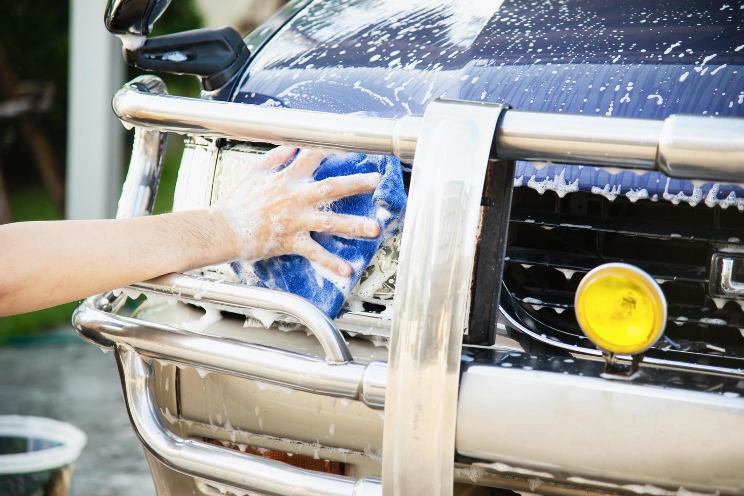 man wast auto met shampoo - autoverzorgingsconcept voor het dagelijks leven foto