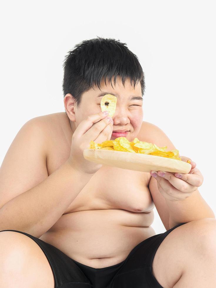 dikke jongen eet vrolijk chips foto