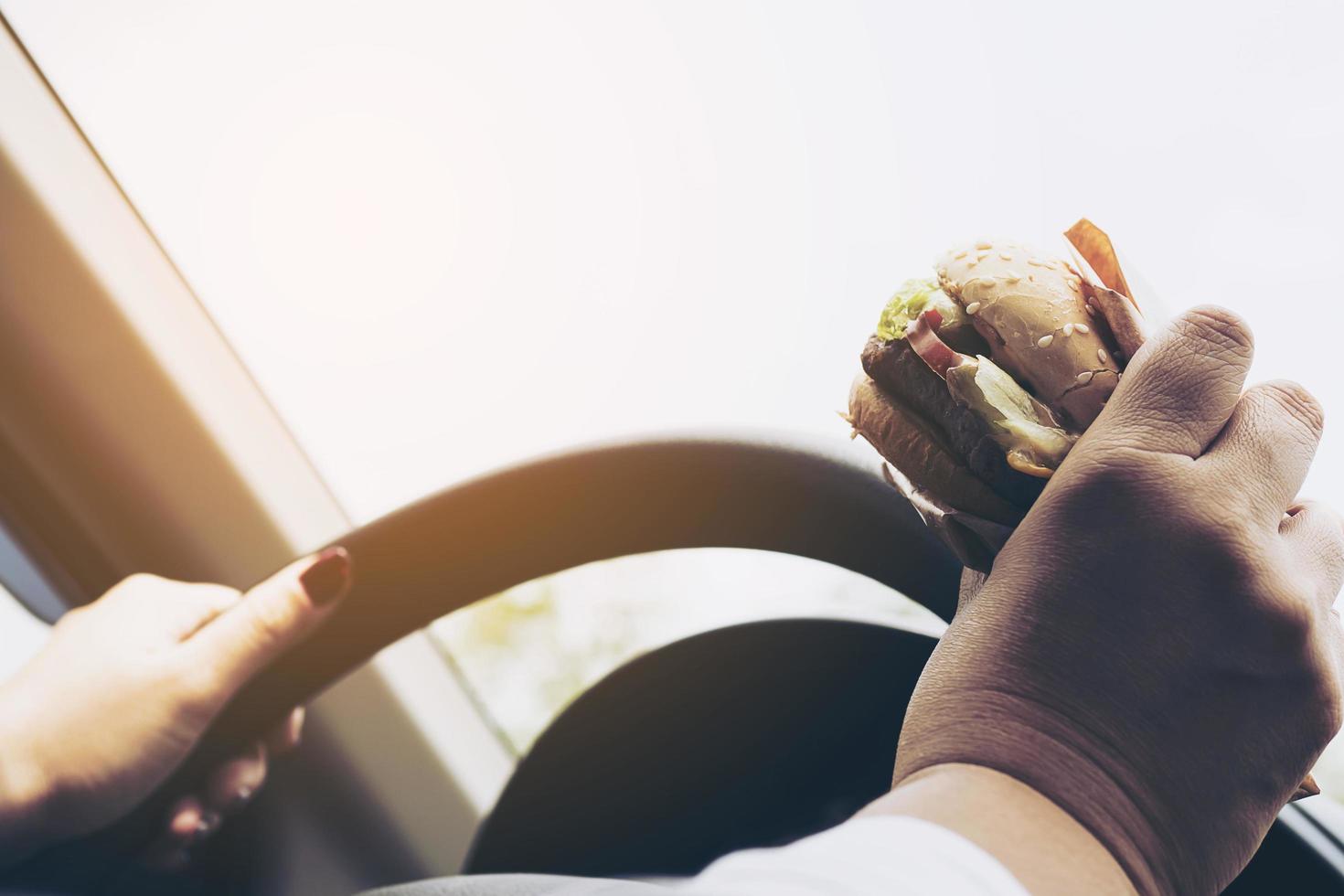 vrouw rijdende auto hamburger eten foto