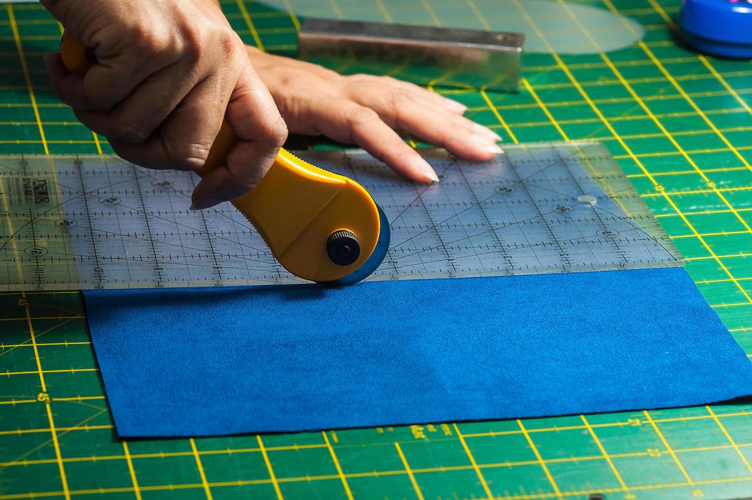 doek snijproces - vrouwenhanden met behulp van roterende snijder voor haar patchwork foto