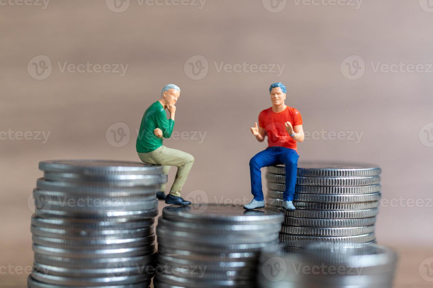 miniatuurmensen een zakenman zit bovenop een berg geld foto